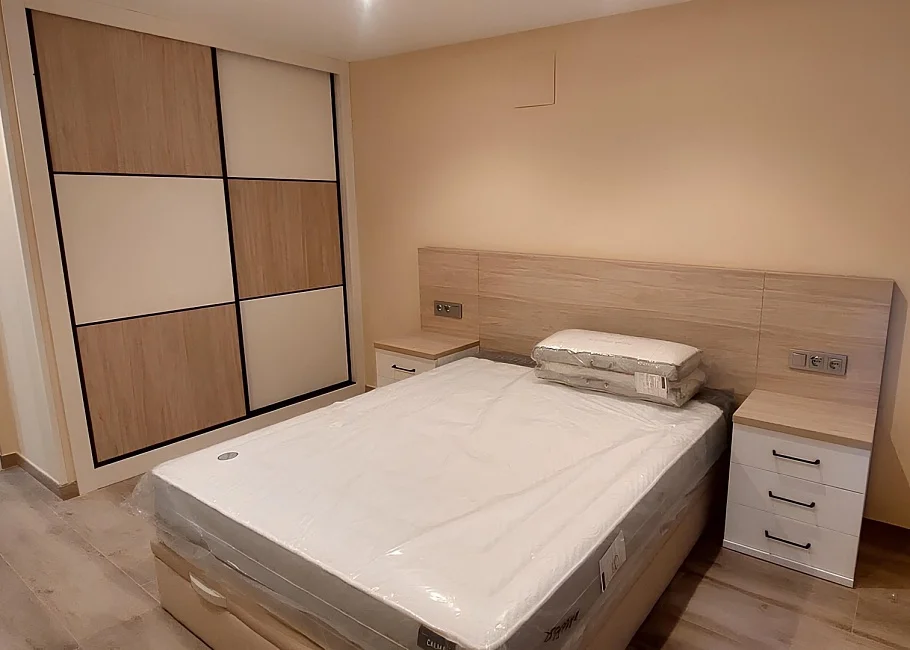 Dormitorio moderno a medida con armario de puertas correderas y cabecero integrado