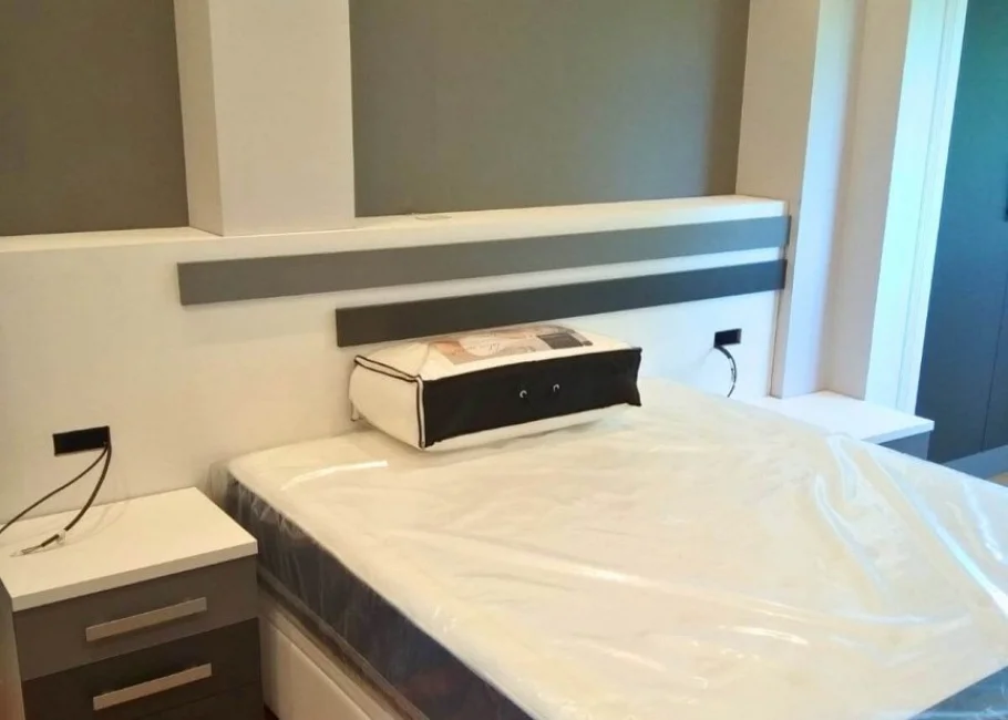 Dormitorio de matrimonio moderno con armario a medida y cabecero decorativo