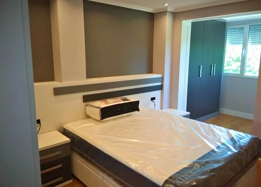 Dormitorio de matrimonio moderno con armario a medida y cabecero decorativo