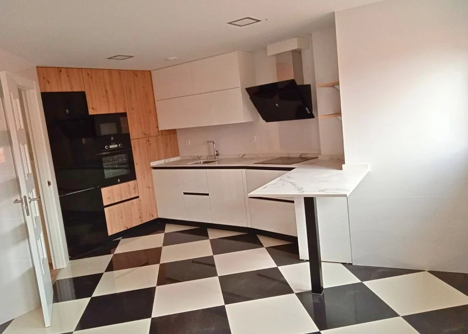 Cocina moderna en blanco y madera con barra integrada