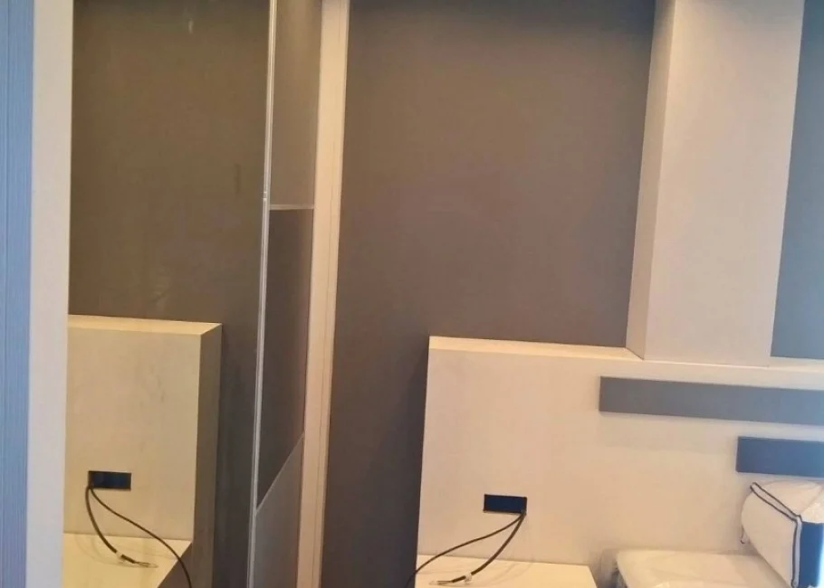 Dormitorio de matrimonio moderno con armario a medida y cabecero decorativo