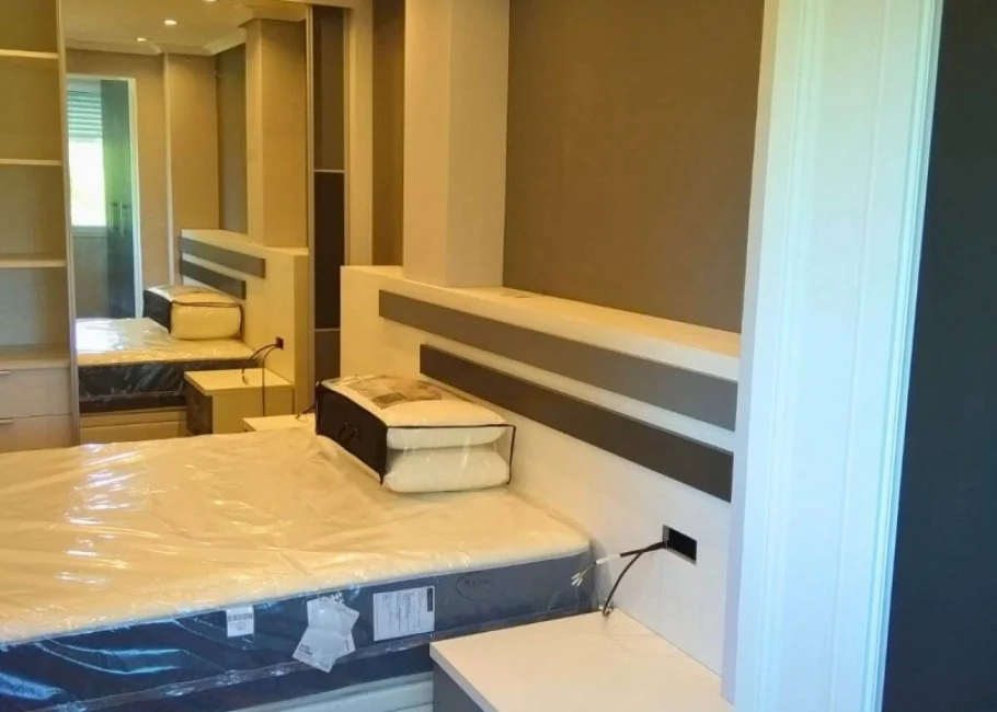 Dormitorio de matrimonio moderno con armario a medida y cabecero decorativo