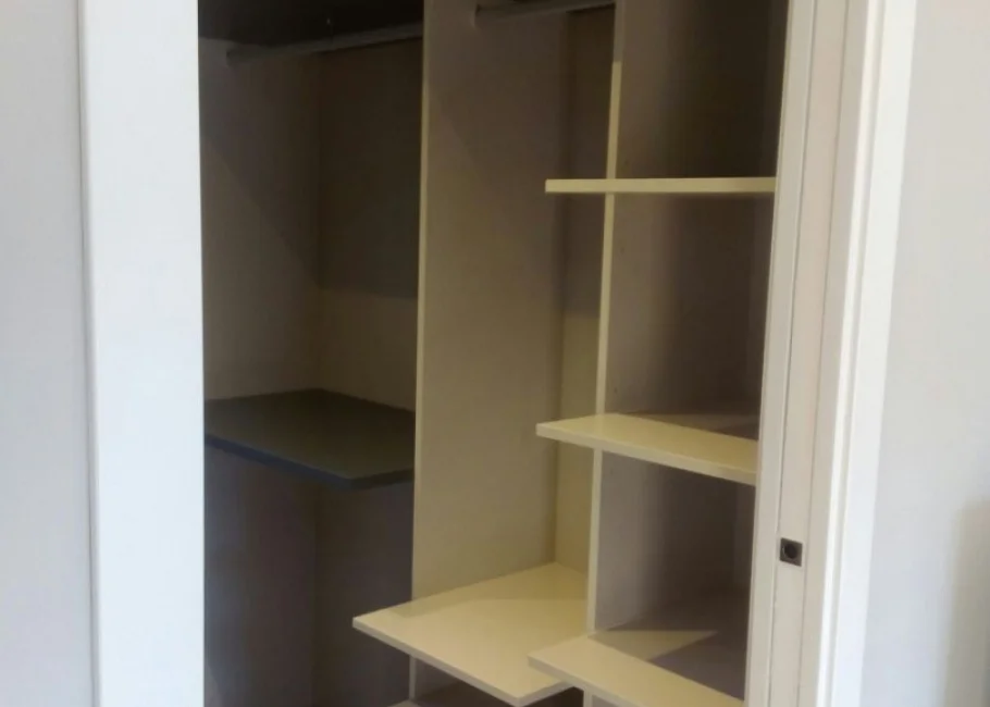 Vestidor diseñado a medida entre dormitorio y baño Vestidor diseñado a medida entre dormitorio y baño