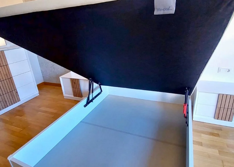 Dormitorio moderno con cama abatible y cabecero en madera alistonada