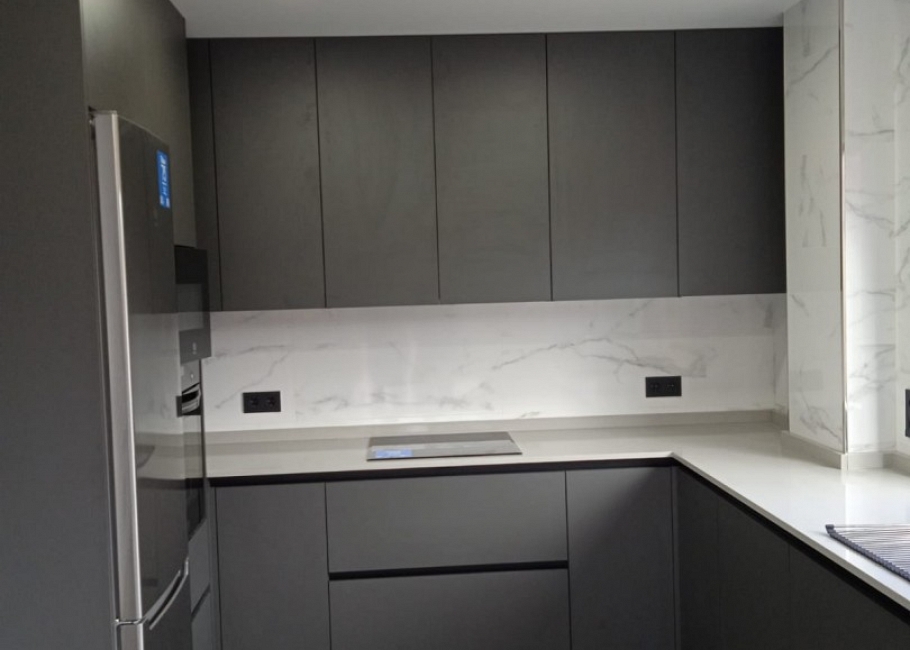 Cocina moderna en tonos antracita con encimera efecto mármol